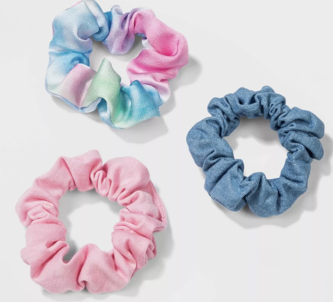 The three scrunchies in pink, blue, and tie-dye 