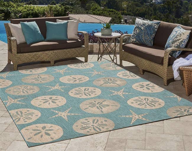 A starfish-patterned blue and nude rug placed next to patio furniture