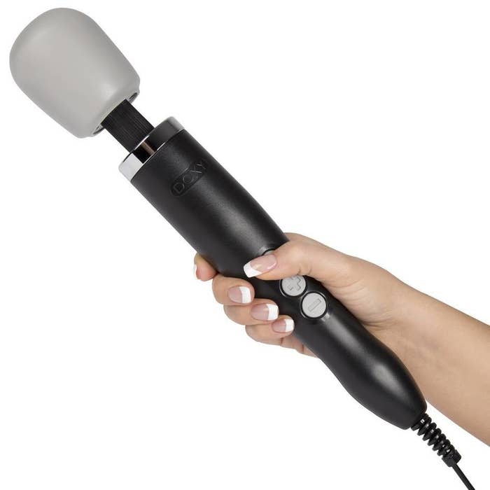 person holding the doxy wand massager with three large buttons visible