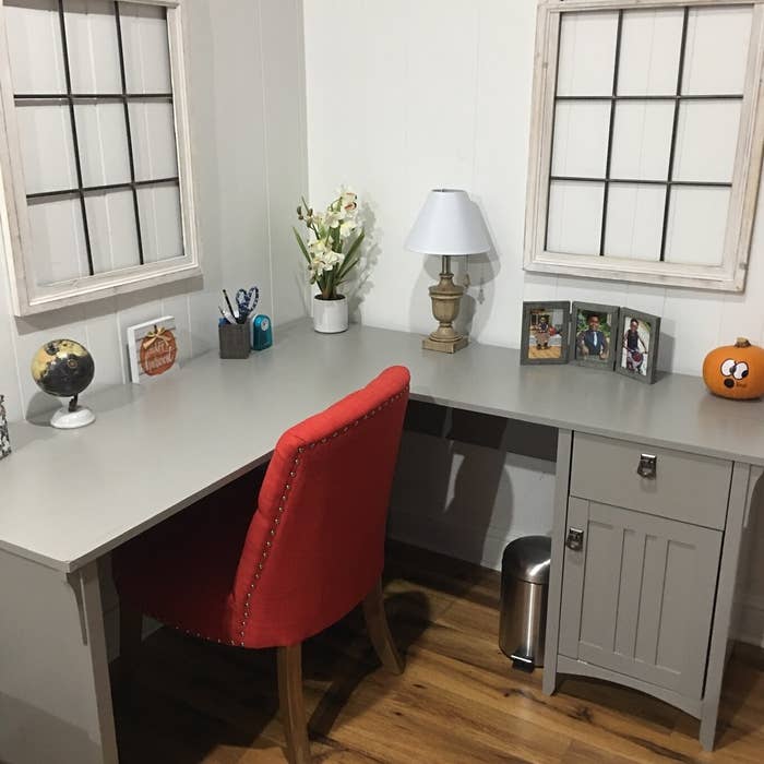 A light gray desk with a side cabinet and drawer