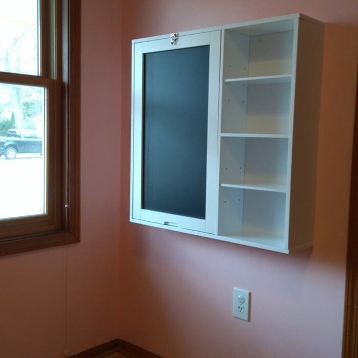 A closed white floating desk with shelves
