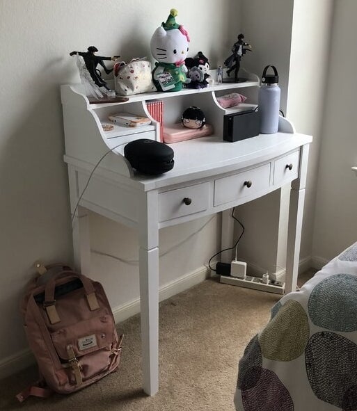 A white desk with drawers, cubbies, and one shelf