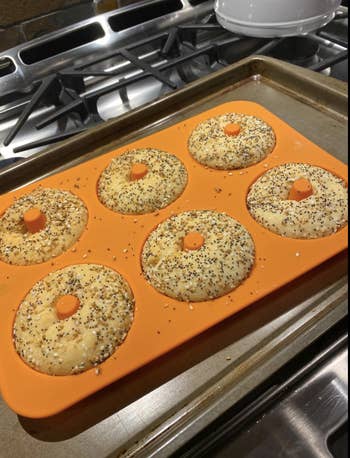 The silicone pan full of six fully baked everything bagels