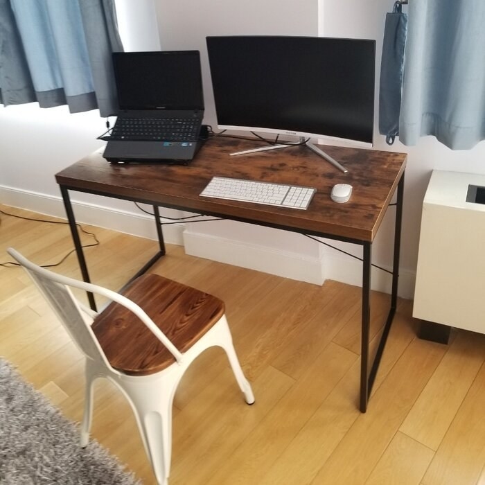 A flat wooden top desk with black metal legs
