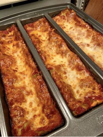 a reviewer's pan with three rectangles of cooked lasagna in it 