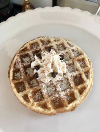 A reviewer's waffle with whipped cream and powdered sugar