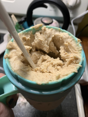 A reviewer dipping a spoon into creamy ice cream