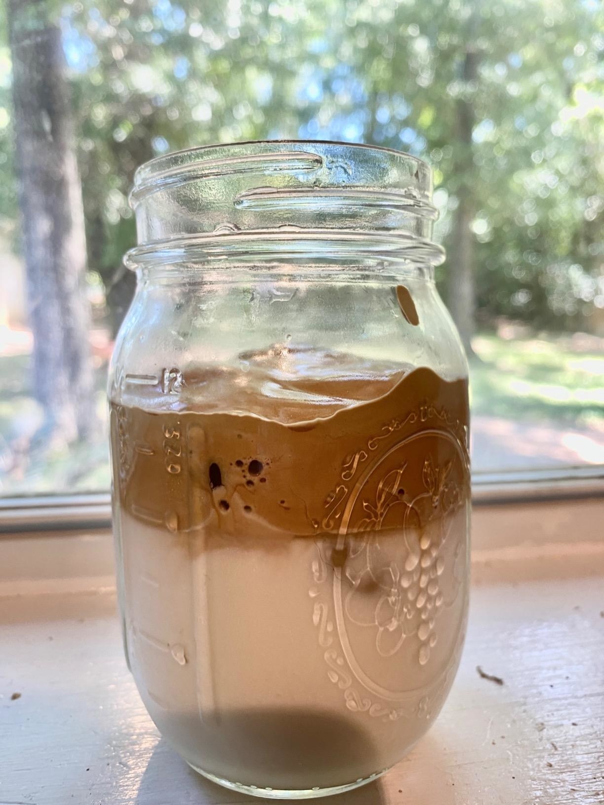 A mason jar with milk and whipped coffee