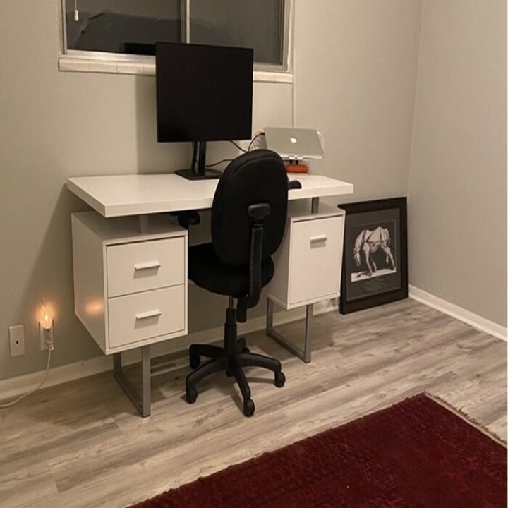 The same desk with a chair, monitor, and laptop