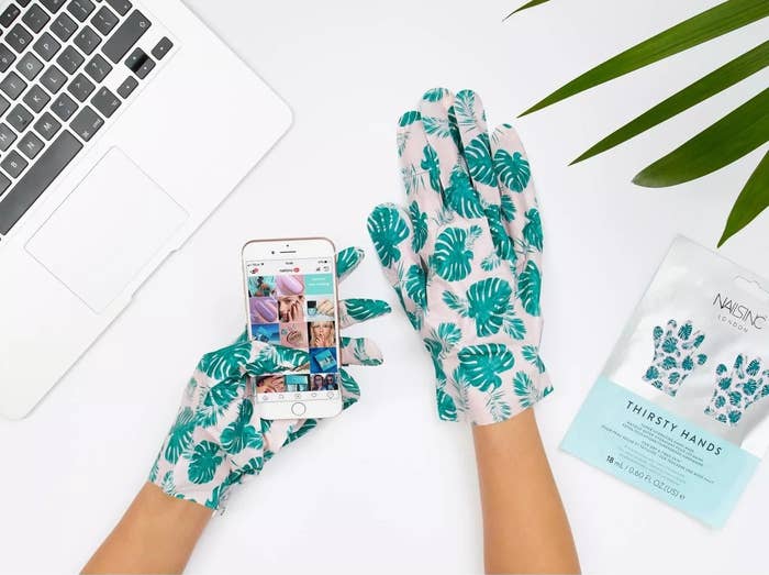 model wearing leaf-covered gloves scrolls through instagram