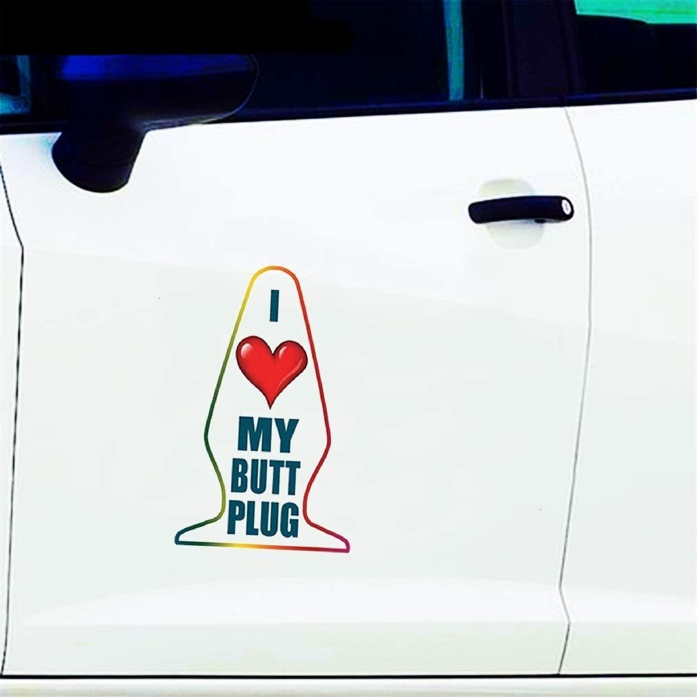 A decal that says I heart my butt plug is pasted on a car door