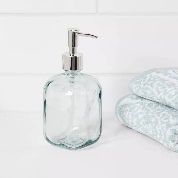 A transparent glass soap dispenser 