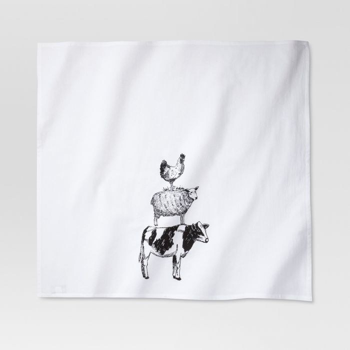 a white towel with a cow, a sheep, and a chicken standing on top of one another