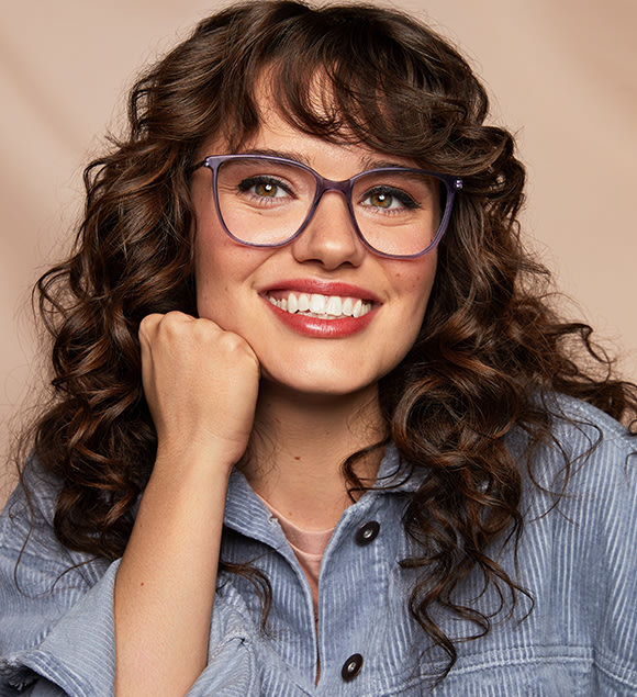 A model wearing a pair of purple framed glasses.