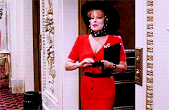 Bette Midler walks in a sleek red dress and slips on sunglasses in the movie &quot;Big Business&quot;