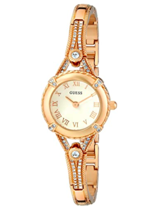 A slim stainless steel watch studded with crystals on a plain background
