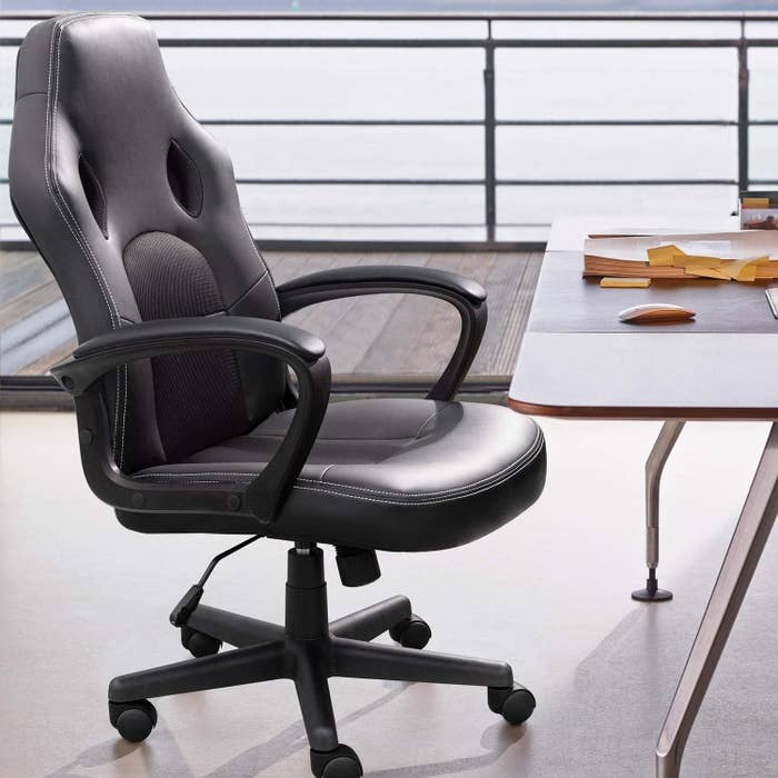a black leather desk chair with padded arm rests at desk