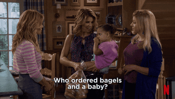 Gif of a woman holding a baby and a bag of bagels.