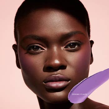 model with deep brown skin wearing the purple shade of blush