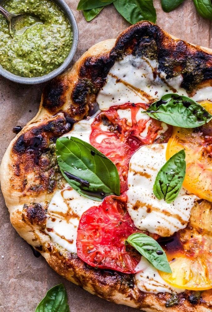 A fresh Caprese pizza with ripe tomatoes, mozzarella, fresh basil, and a balsamic drizzle.