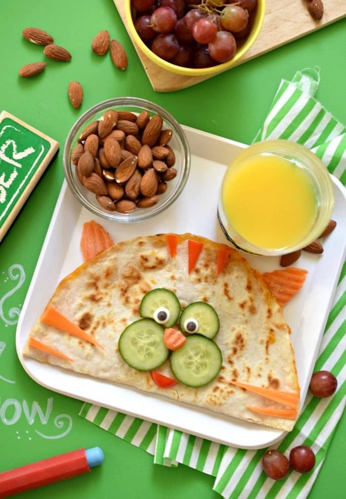 Quesadilla with a cat&#x27;s face made from cucumbers, carrots, and peppers.