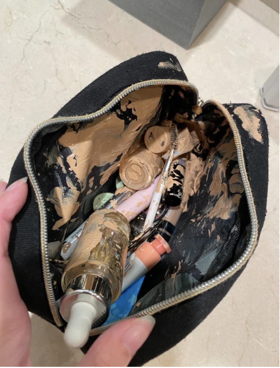 A makeup bag with broken makeup everywhere in it