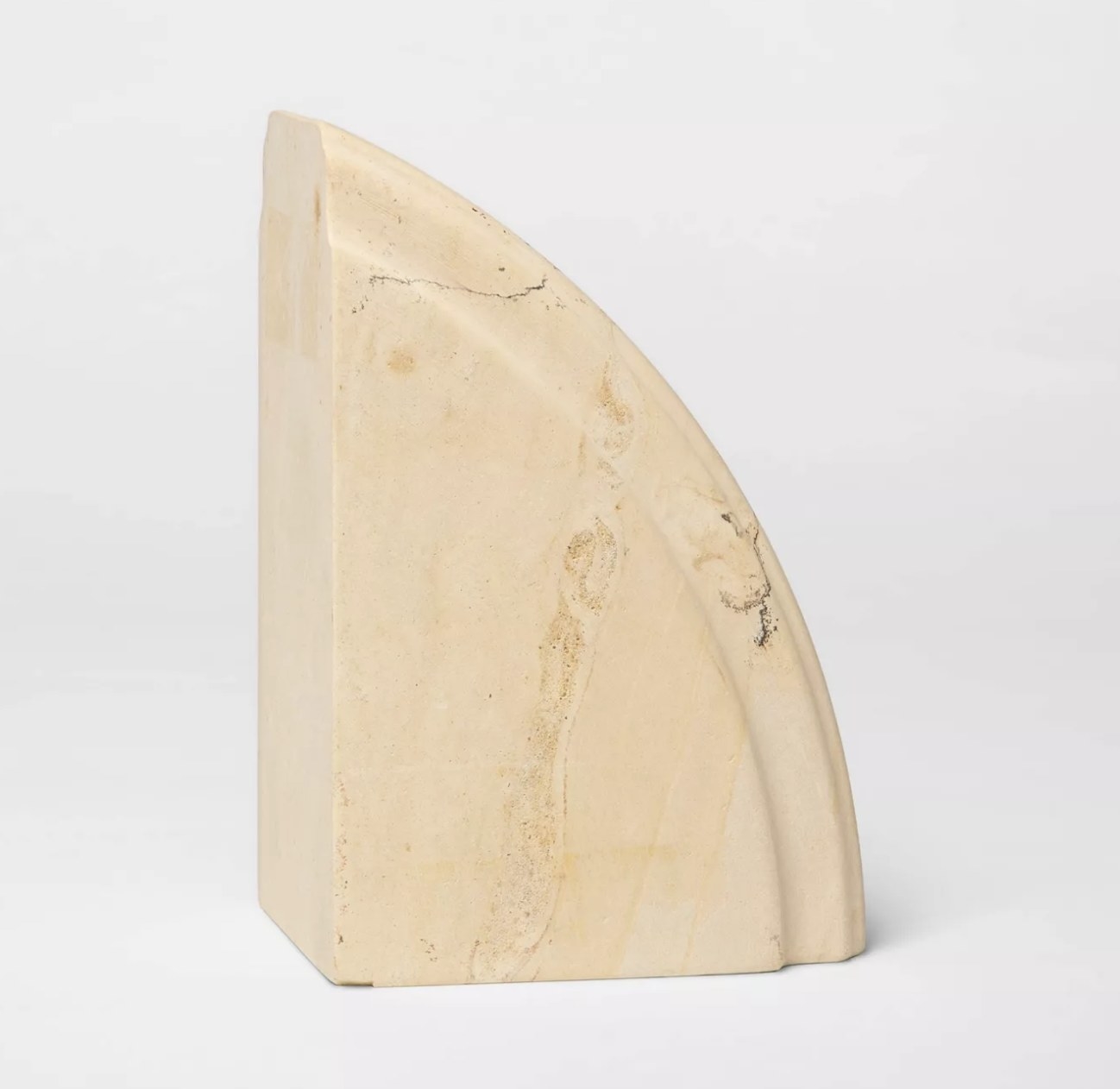 A beige, curved limestone bookend