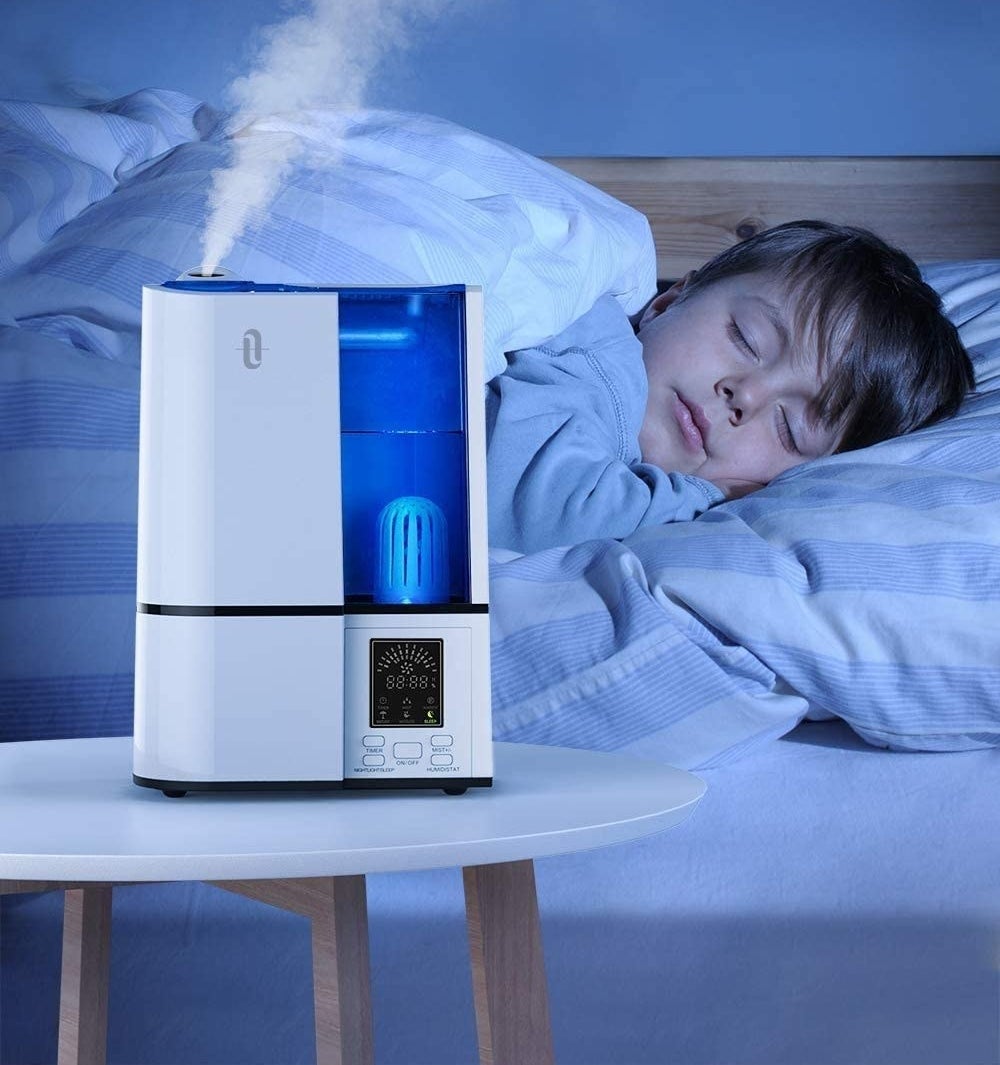 A child sleeping while the ultra sonic humidifier works next to him