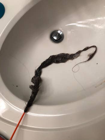 Review image of a clump of hair being pulled from a sink
