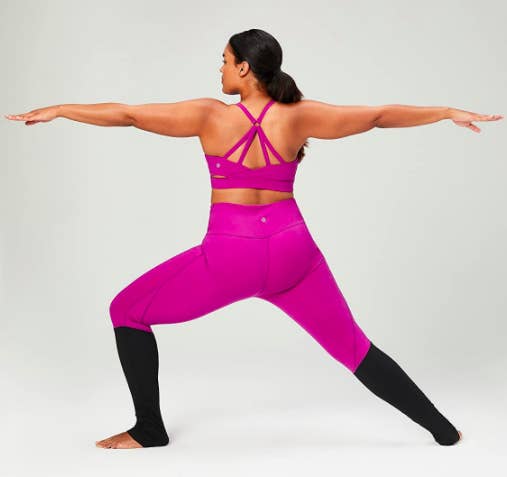 Model wears a pink Core 10 'Icon Series' The Ballerina Sports Bra with a criss-cross design on the back