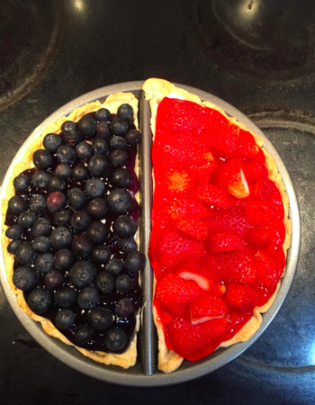A reviewer using the split decision pie pan to make a blueberry pie on one side and a strawberry pie on the other side