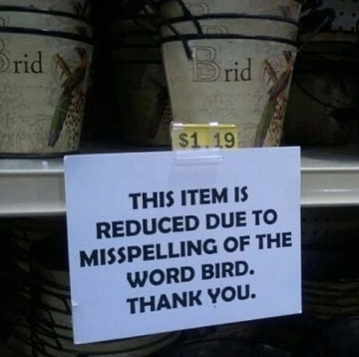 A sign on a store shelf reads &quot;This item is reduced due to misspelling of the word bird thank you.&quot; It is next to a decorated bucket with letters that read &quot;brid&quot;