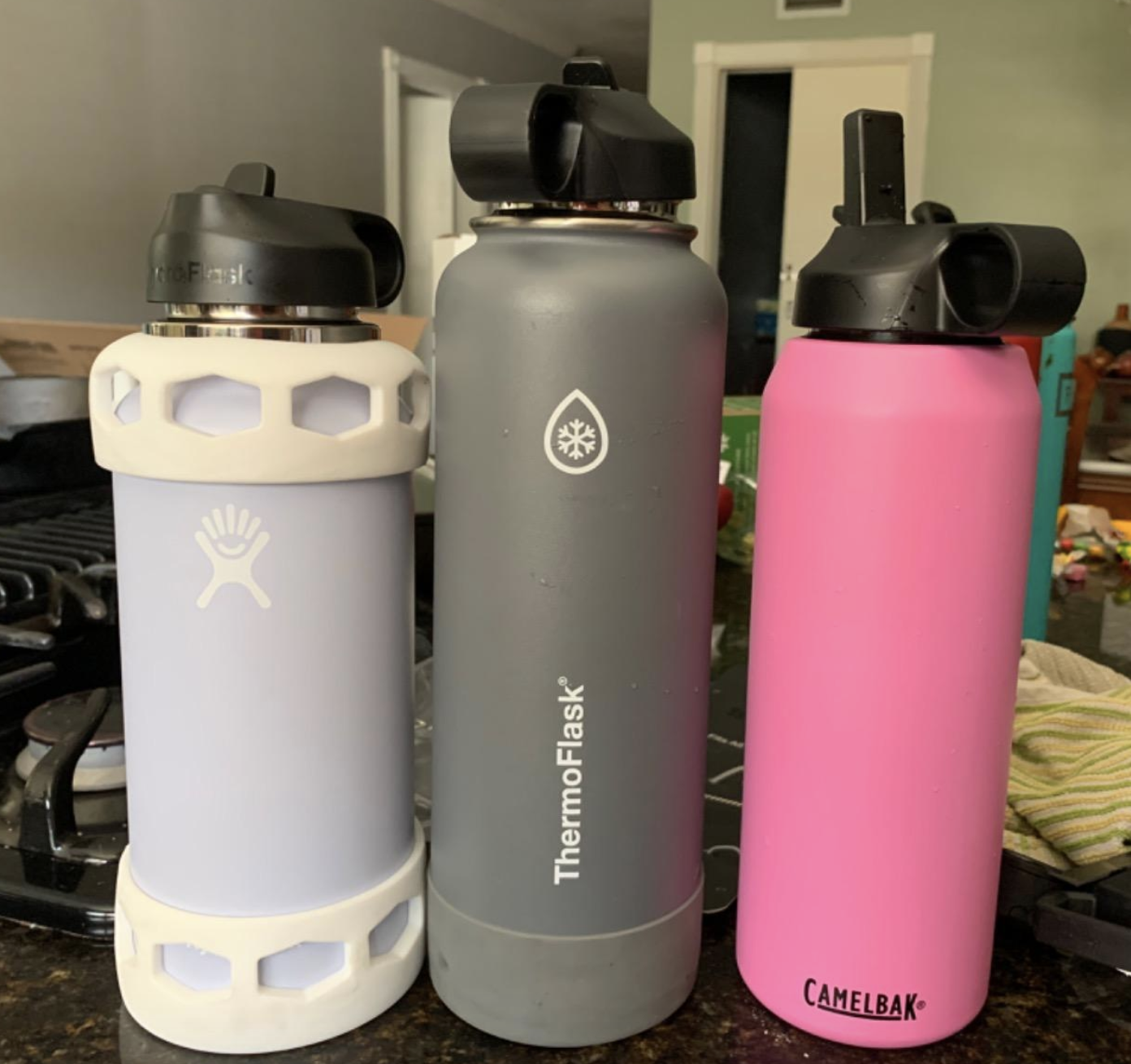 HydroFlask, ThermoFlask, and Camelback water bottles with black lid