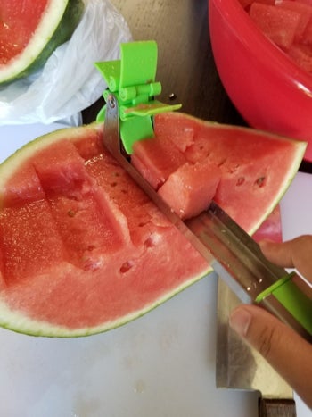 A reviewer pulling up a piece of watermelon using the utensil 