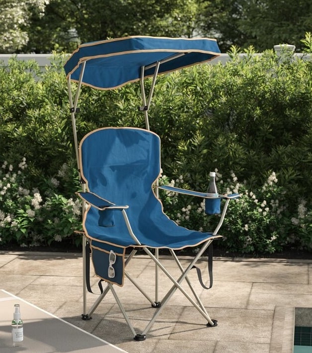 A blue chair with tan trim and metal legs with cup holders and side pocket