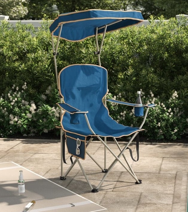 A blue chair with tan trim and metal legs with cup holders and side pocket