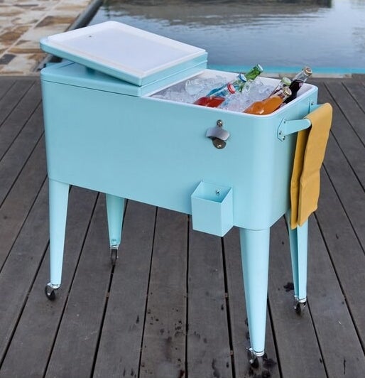 A light blue cooler on caster wheels with the top open revealing ice and cold beverages