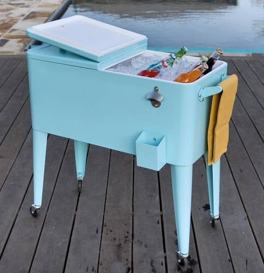 A light blue cooler on caster wheels with the top open revealing ice and cold beverages