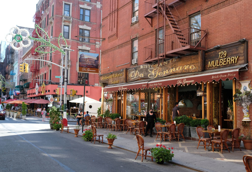 A restaurant in Little Italy serves customers seated at sidewalk tables