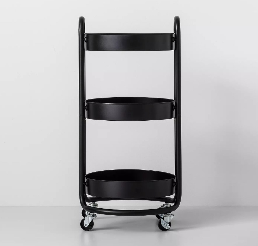 a round black cart with three trays for storage