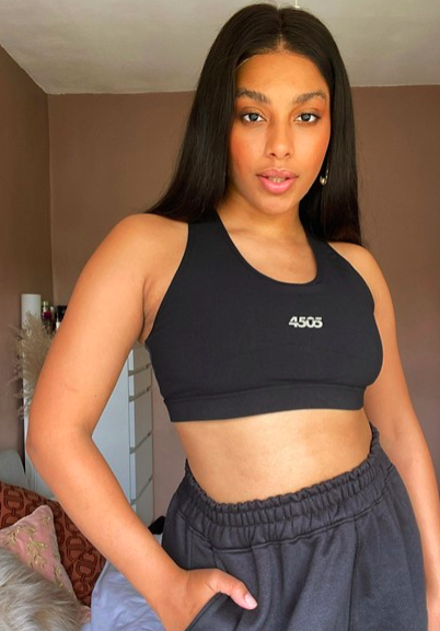 Model wears black scoop neck sports bra that says &quot;4505&quot; on the front