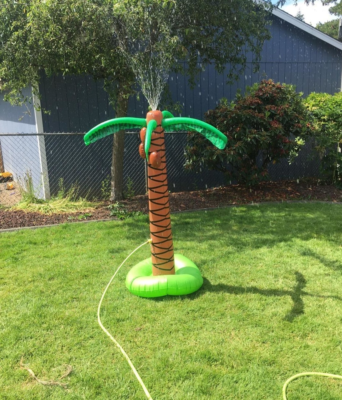 inflatable palm tree with hose attached spraying water out its top