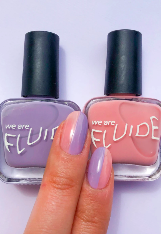 The lavender and pink shade of nail polish on a model's fingernails