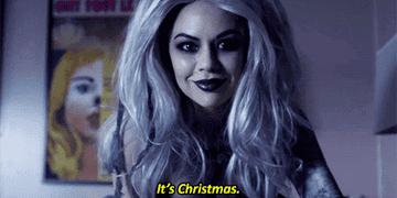 Mona in a ghost outfit and wig saying &quot;It&#x27;s Christmas&quot;