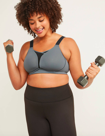 front of a model wearing a gray wire-free sports bra while lifting dumbbells 
