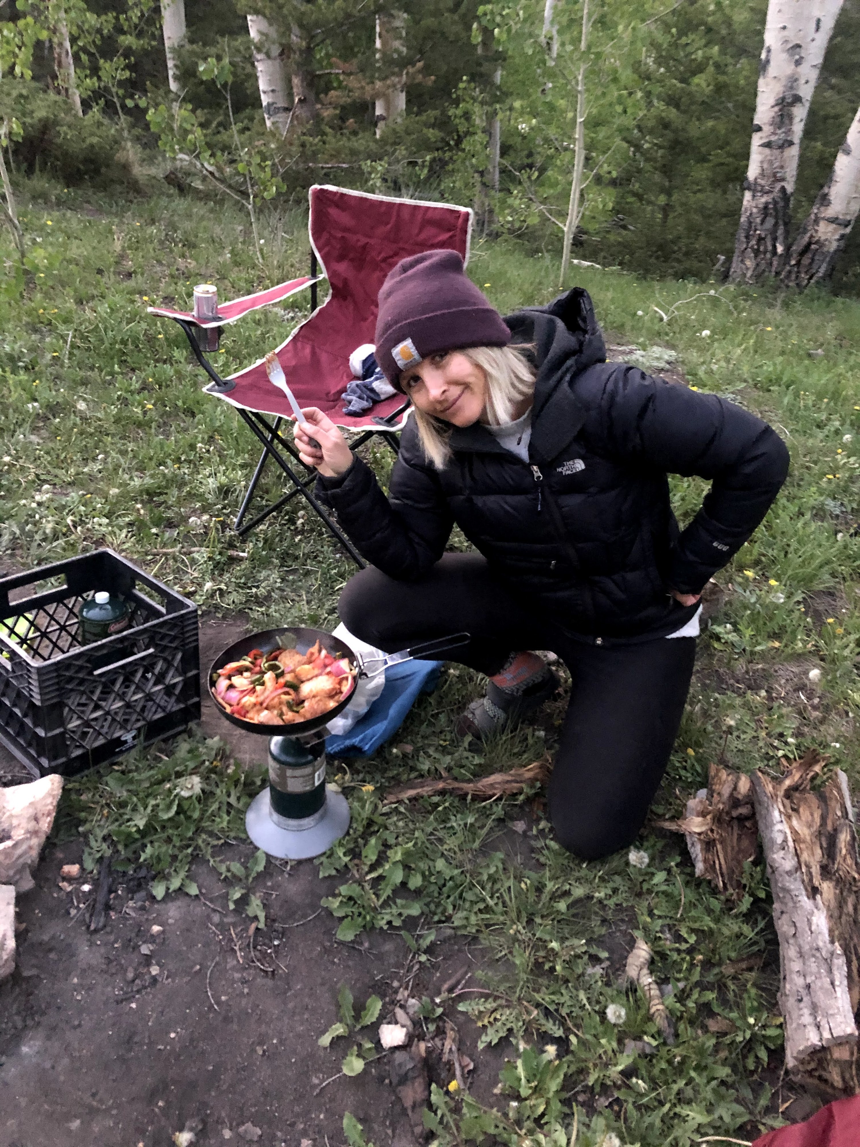 Woman cooking vegetables on a camping stove