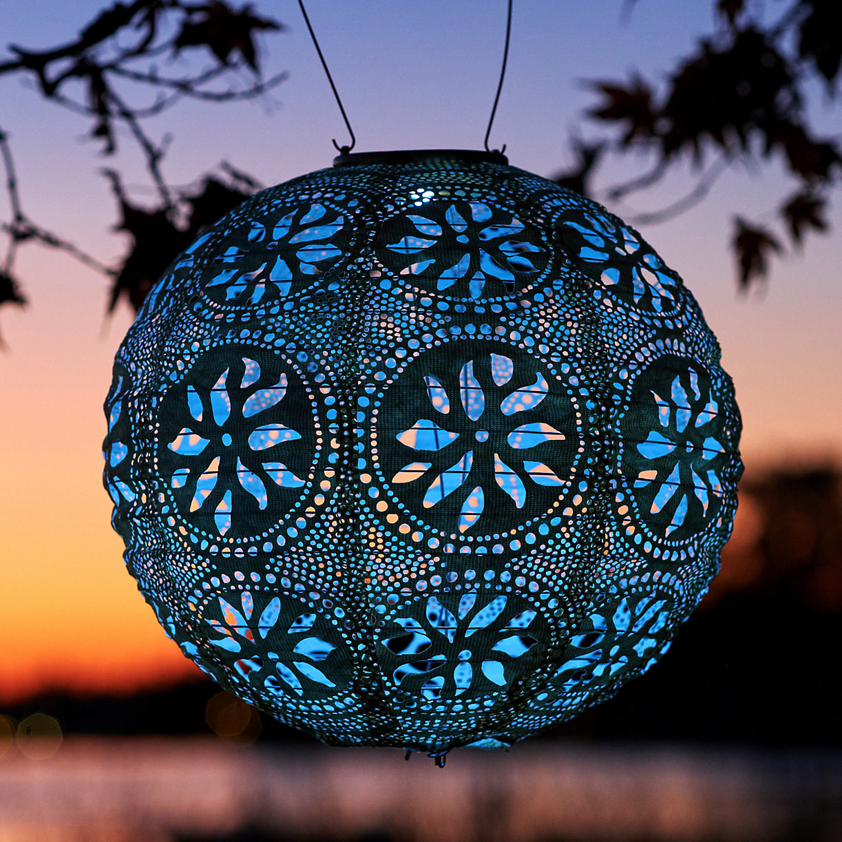 blue floral round lacy lantern hanging and illuminated