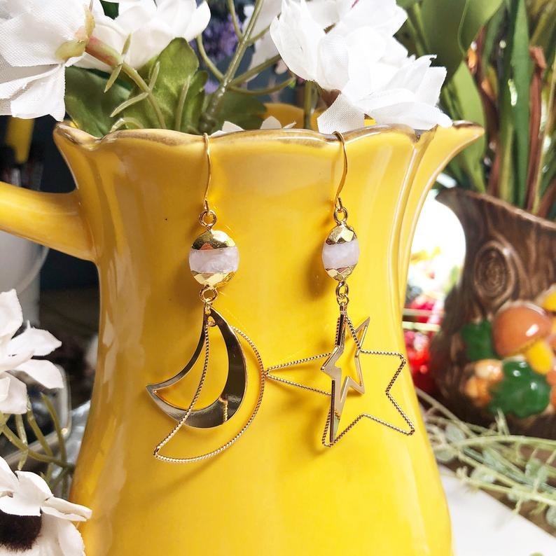 The moon and star shaped earrings hanging on a yellow flower pot