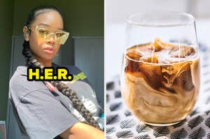 H.E.R. wears a long braid and yellow-tinted sunglasses. She is sporting a black band tee shirt while sitting in a bedroom. Next to H.E.R. is an iced coffee in a wine glass, sitting on a leaf-patterned napkin.
