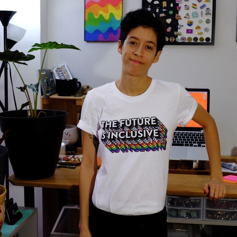 Model wearing the T-shirt that says &quot;the future is inclusive&quot; in rainbow lettering 